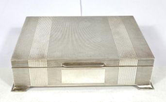 A hallmarked silver cigarette box, engine turned, on bracket feet, Birmingham 1961