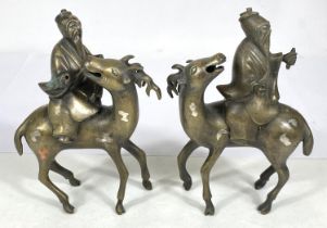 A pair of Chinese brass censors in the form of men riding deer (some loss) ht. 17cm