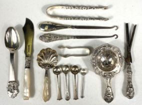 A hallmarked silver pair of pierced sugar tongs; a shell bowl caddy spoon with mother-of-pearl