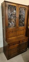 A Jaycee Furniture oak Jacobean style full height display cabinet with leaded glass doors above,