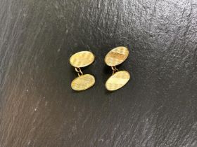 A 9 carat gold pair of oval cufflinks with wave engraving, 12.5gm