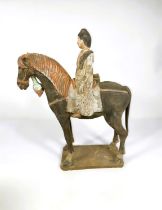 A Chinese under glazed pottery figure on horseback, in the archaic style, painted decoration, 38cm