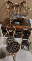 A rosewood sewing box with various compartments and a miniature wicker seating set