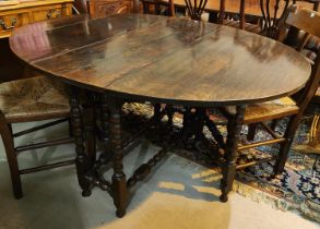 An 18th century oak dining table with oval top on bobbin turned gate legs