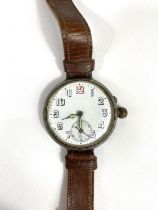 A large silver cased officers trench watch with screw in movement, seconds dial, leather strap