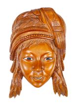 A Far Eastern carved wooden wall hanging face with bone inset eyes and teeth, 20cm