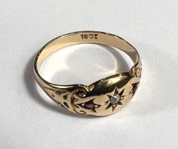 A lady's gold dress ring with central diamond in star cut surround flanked by 2 small rubies,