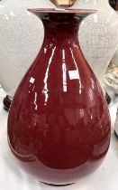A Chinese Oxblood glazed vase with bulbous body, flared rim, associated stand, ht. 35cm incised mark