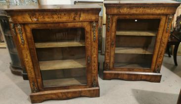 A mid 19th century pair of walnut pier cabinets in the French manner with ornate ormolu mounts and