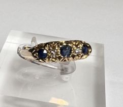 An 18ct hallmarked gold 'gypsy' style dress ring set with 3 sapphires and 2 small diamonds, 3.2gm,