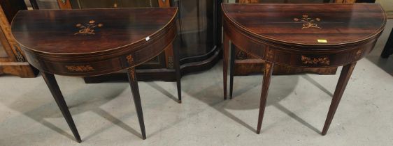 A pair of Sheraton period rosewood card tables, the fold-over demilune tops with boxwood line and