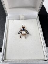 A pendant in the form of a Bee with cabochon sapphire and pearl body, wings set with 2 diamonds