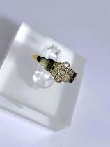 A yellow metal dress ring stamped '18ct plat' set 7 diamonds as a flowerhead, 2.8gm, size K