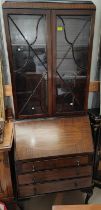A 1920's mahogany bookcase with 2 glazed doors over fall front, 3 drawers and cabriole legs