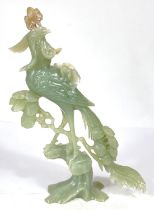 A Chinese jade coloured hardstone carving of bird on floral branch of tree, ht. 27cm