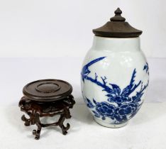 A Chinese blue and white vase with wooden lid and wooden carved stand, decorated with birds and