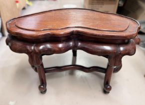 A 19th century Chinese hardwood stand with lotus leaf frieze, carried on 3 legs united by a shaped