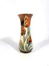 A modern Moorcroft waisted vase decorated with tulips against a brown ground, stamped and
