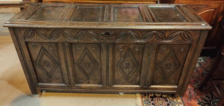 A 19th century carved panel fronted chest with hinged lid