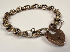 A yellow metal bracelet with a 9ct gold heart shaped locket (bracelet tests as 9ct approx) 12.8gms.