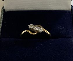 A 3 stone diamond lady's dress ring in crossover style setting, the shank stamped 18ct PLAT, 2.