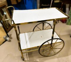 An early to mid 20th century cocktail trolley with glass shelves in gilt