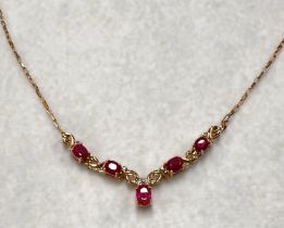 A yellow metal necklace, stamped '375', set diamonds and rubies in 'V' formation