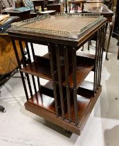 An Edwardian mahogany revolving bookcase with brass gallery