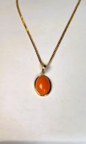 A 9ct gold chain (5.4gms) set with coral coloured cabochon yellow metal surround