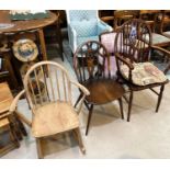 A Windsor wheelback armchair; an Ercol dining chair; an Ercol lightwood stick back rocking chair