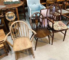 A Windsor wheelback armchair; an Ercol dining chair; an Ercol lightwood stick back rocking chair