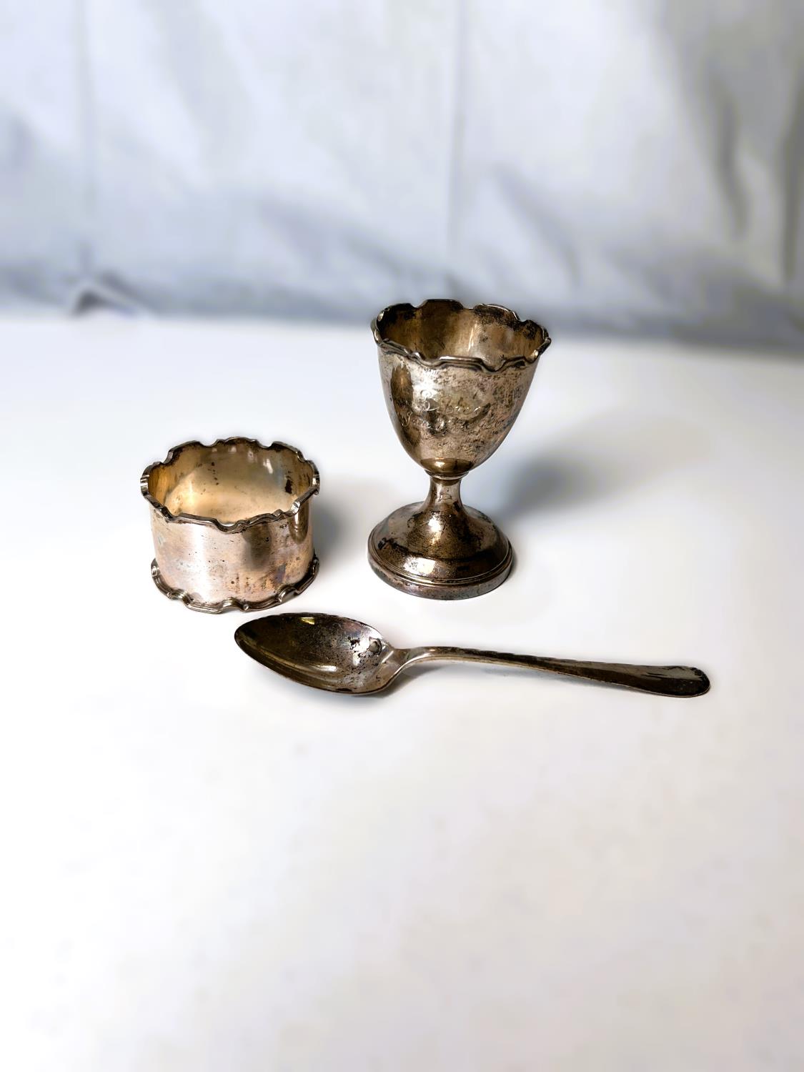 A hallmarked silver originally boxed 3 piece christening set comprising egg cup, teaspoon and napkin