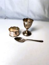 A hallmarked silver originally boxed 3 piece christening set comprising egg cup, teaspoon and napkin