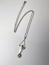 An Art Deco cruciform style white metal pendant with diamond drop, tests as 9ct, on fine chain