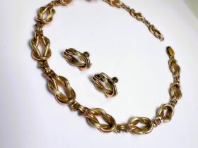 A vintage two tone Art Deco style necklace formed from Reef knot links, stamped "1/20 12K"; a
