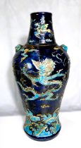 A Chinese dark blue ground vase decorated with dragons in relief, tapering neck, height 43cm.