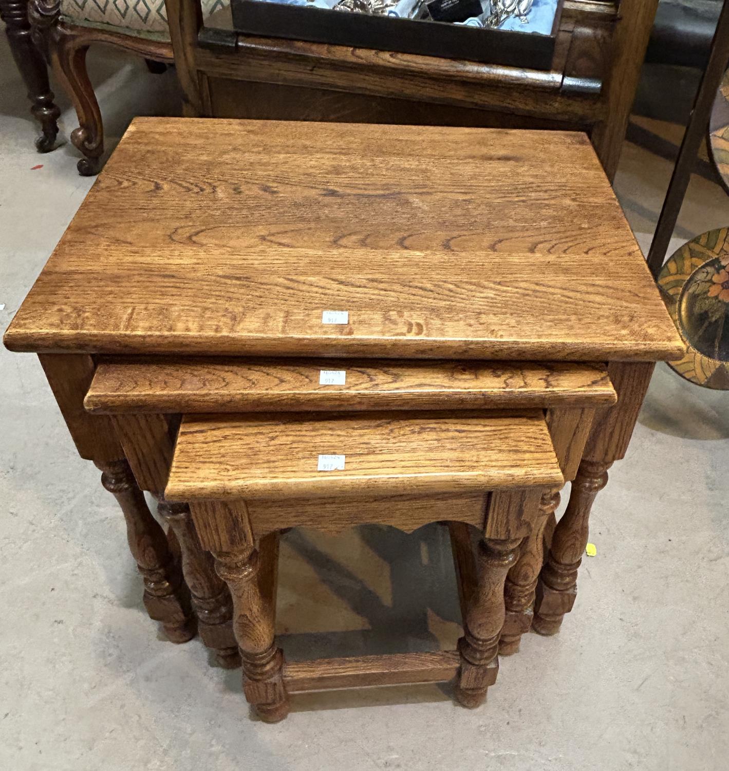 A nest of 3 light oak occasional tables