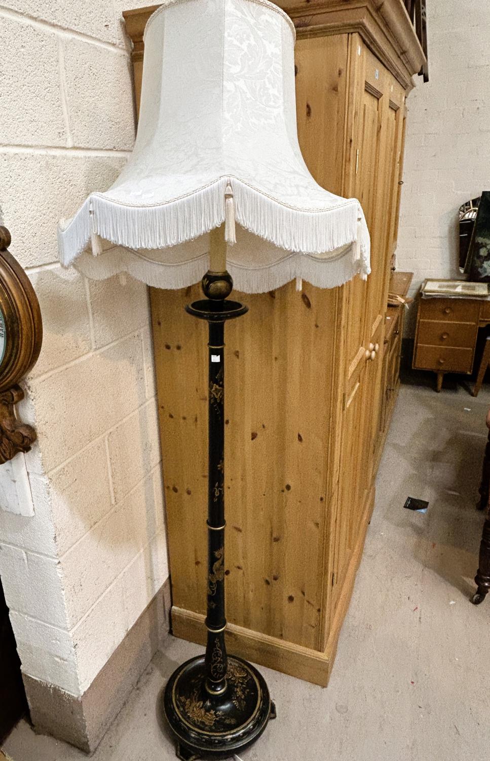 An early 20th century standard lamp, black lacquered with cream shade