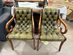 A pair of green leather effect deeply button back desk chairs with scrolling arms, studded