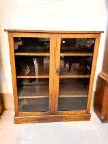 An early 20th century mahogany cabinet enclosed by 2 glazed doors