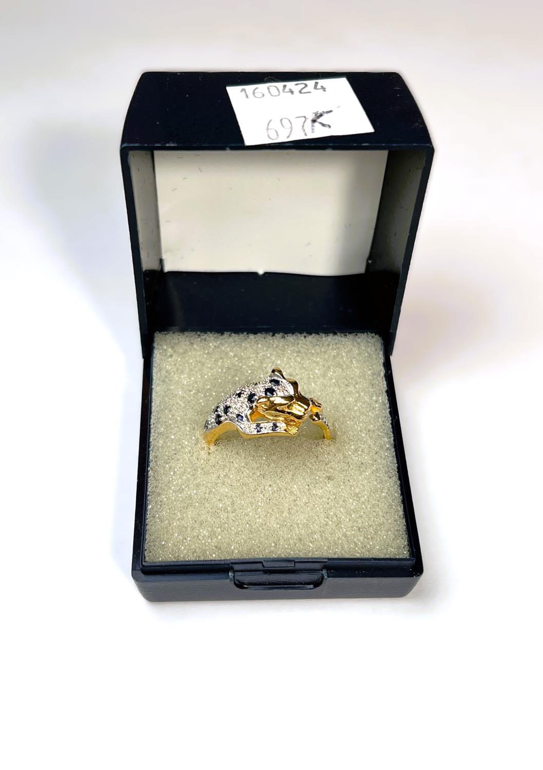 An 18ct gold dress ring in the form of tiger set with diamond chips and sapphires, with green