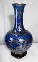 A Chinese bulbous, dark blue ground vase with gilt decoration of dragons etc., tapering and