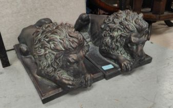 A pair of good sized bronzed composition threshold lions reclining, length 45cm