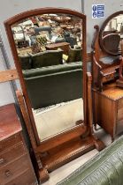 A Victorian mahogany framed cheval mirror with arch top and reeded side supports, on plinth base,