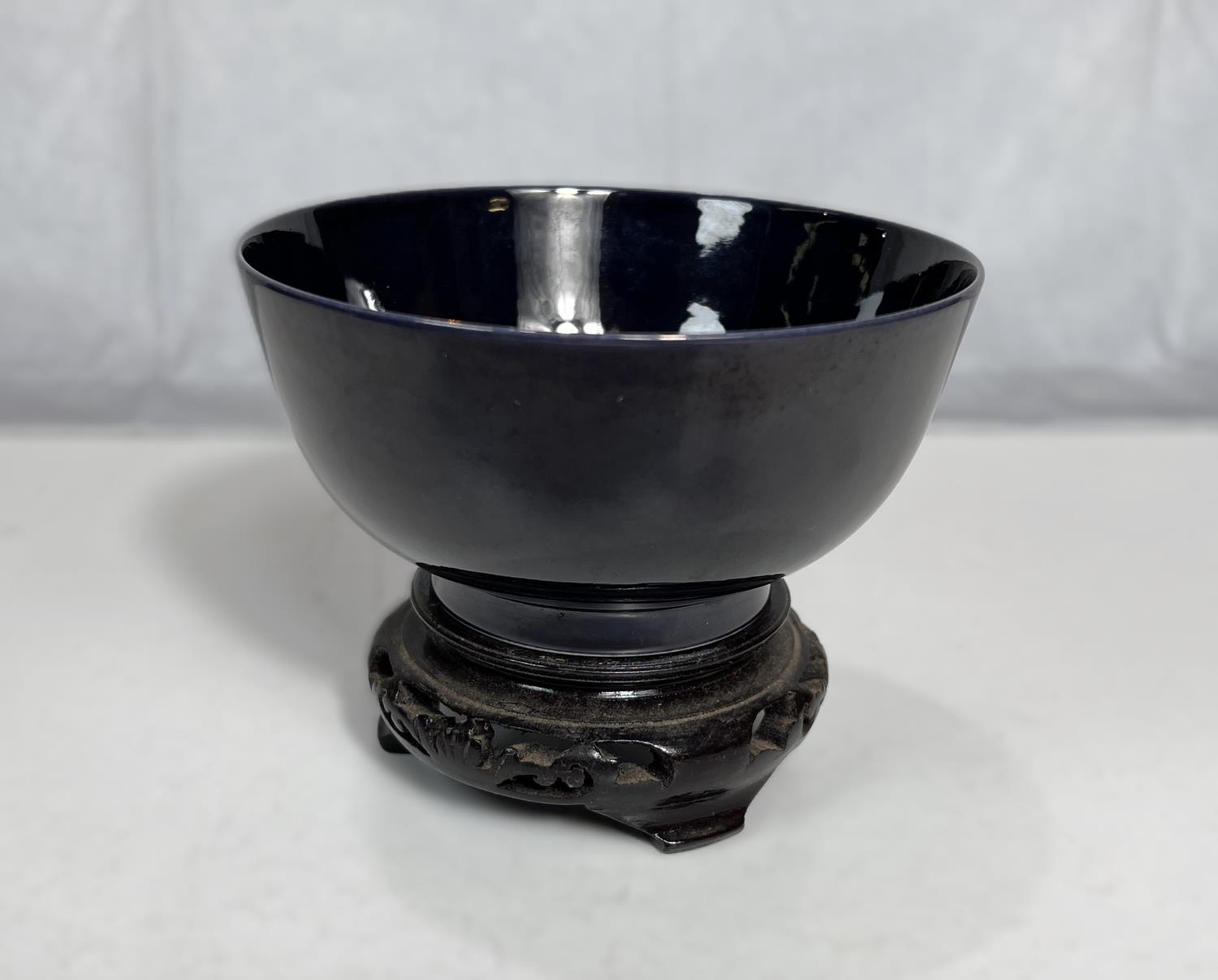 A Chinese dark blue monochrome bowl with 6 character mark to base, associated wooden stand, diameter