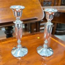 A hallmarked silver pair of candlesticks with weighted bases