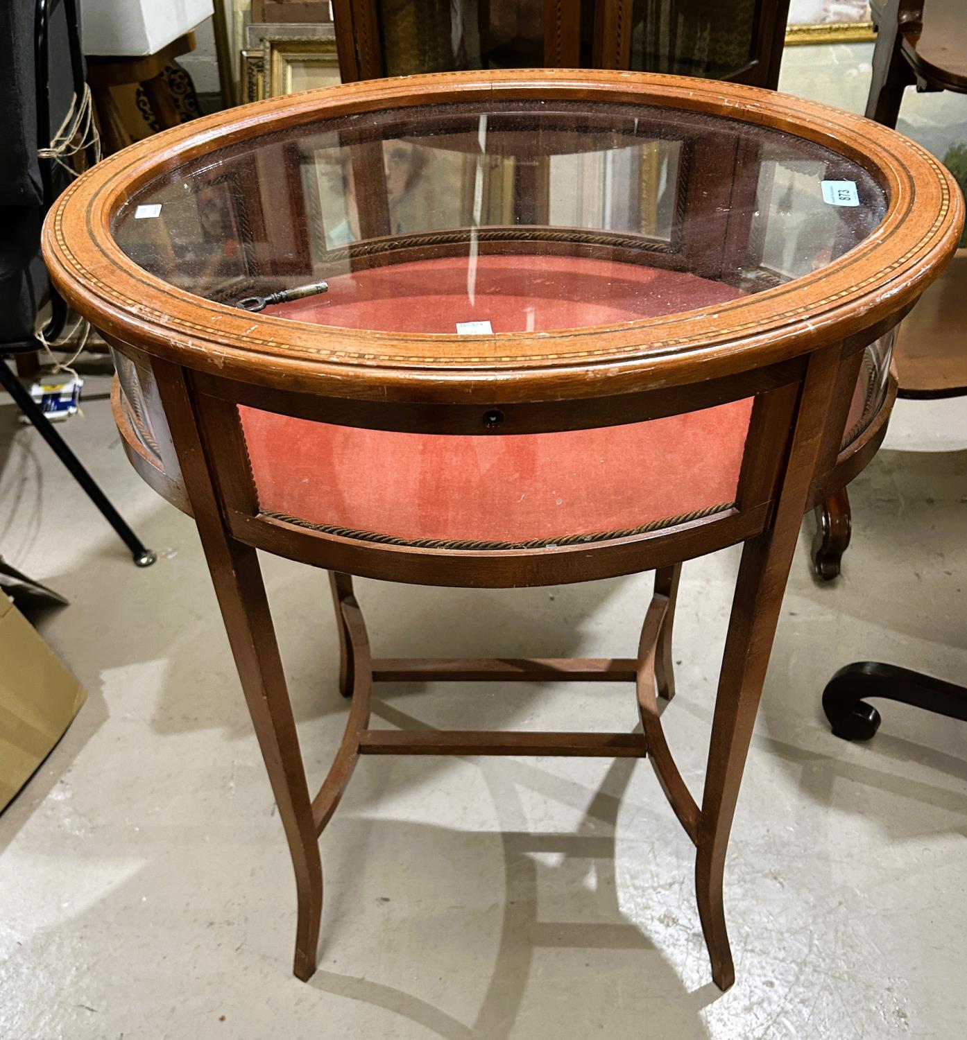 An Edwardian oval bijouterie cabinet in Sheraton style inlaid mahogany, on square tapering legs