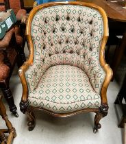 A Victorian walnut framed deeply buttoned armchair with rounded back