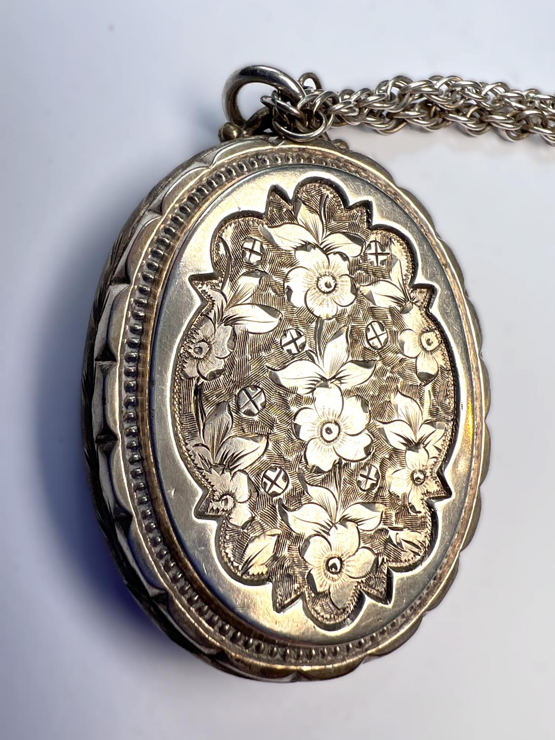 An oval chased white metal locket on later 'Prince of Wales' silver chain, length of chain 74cm - Image 3 of 4