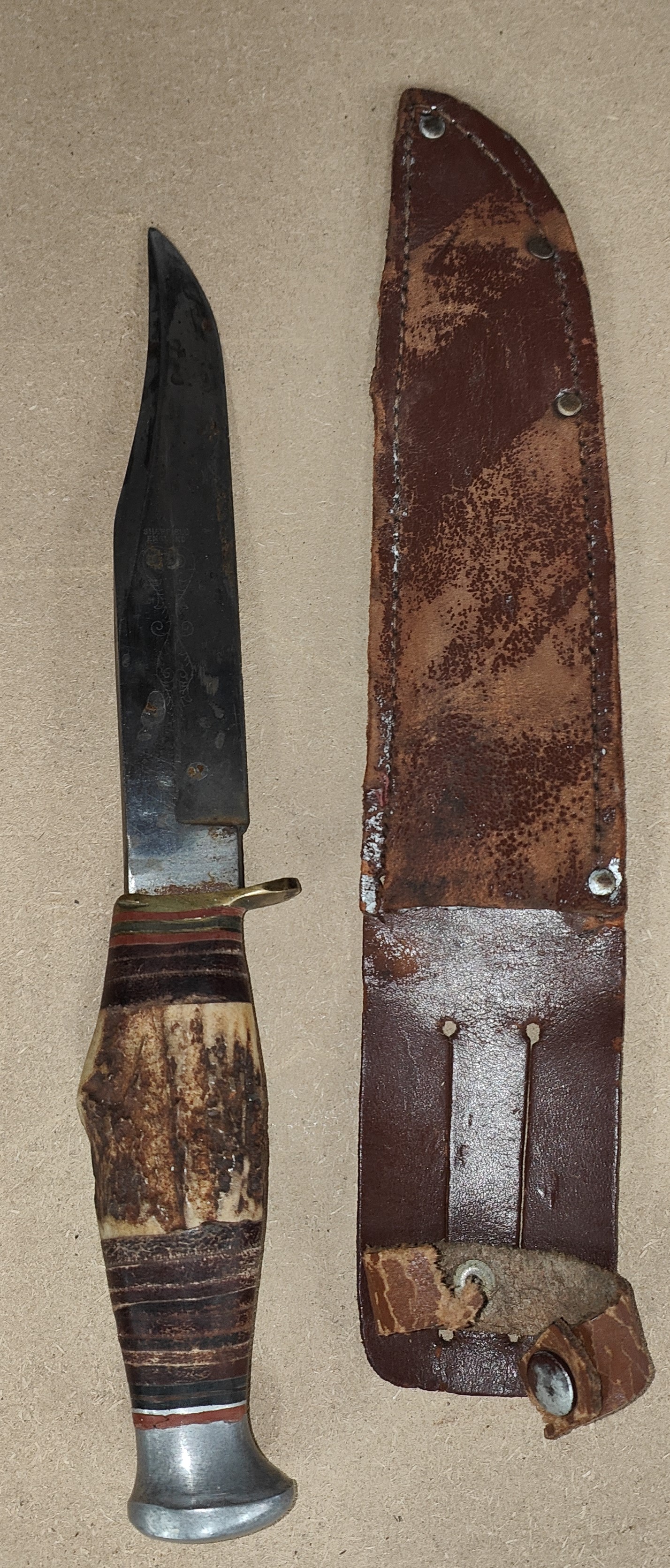 A late 19th/early 20th century Bowie knife with horn handle, leather sheath